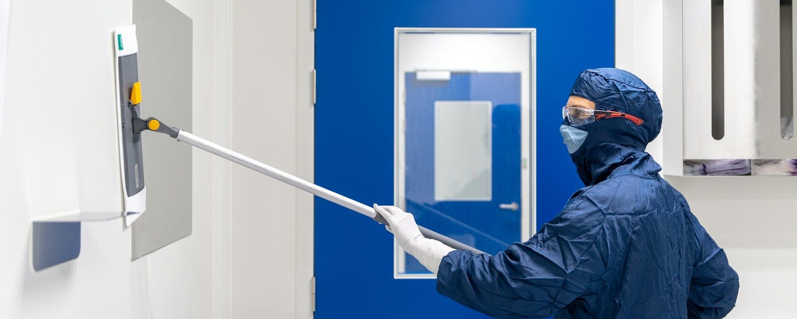 Operator disinfecting a cleanroom
