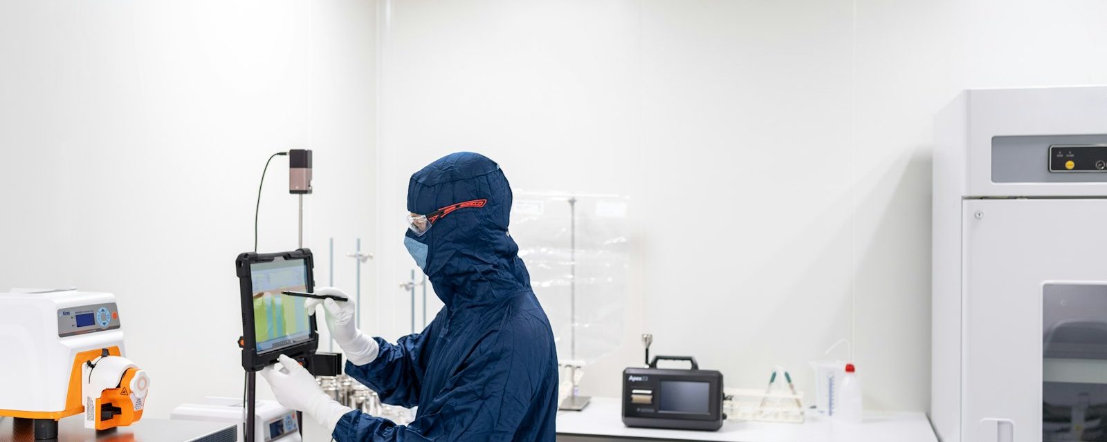 Technician with a particle counter in a GMP cleanroom